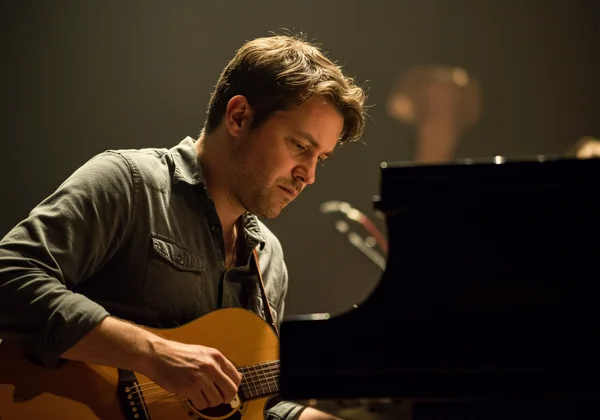 Musician with focused expression internalizing rhythm.